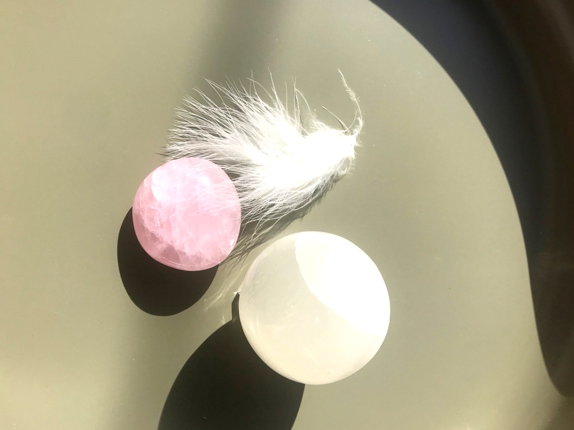 Objets symboliques : sélénite, quartz, plume blanche