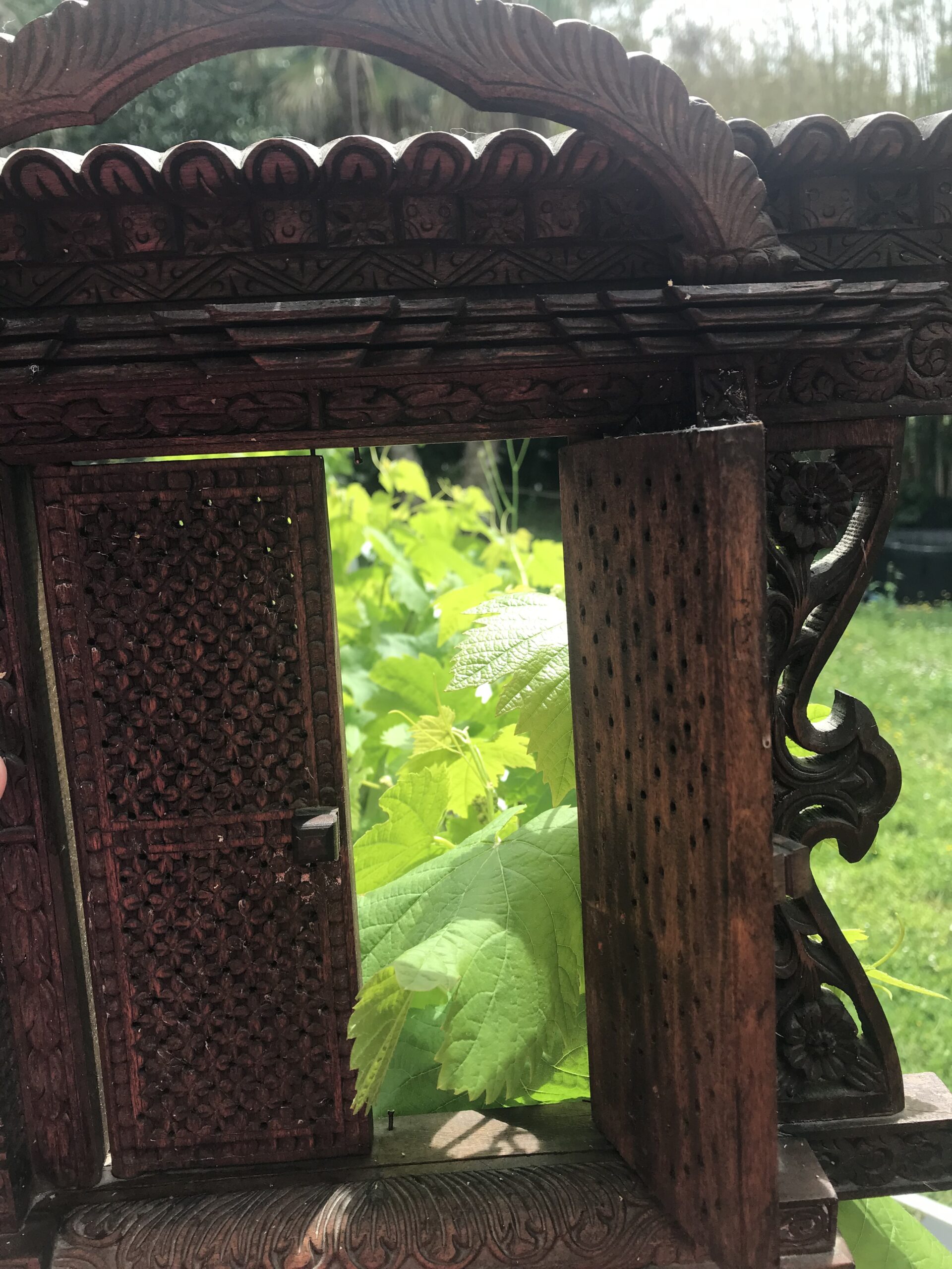 Porte sculptée ouverte sur jardin