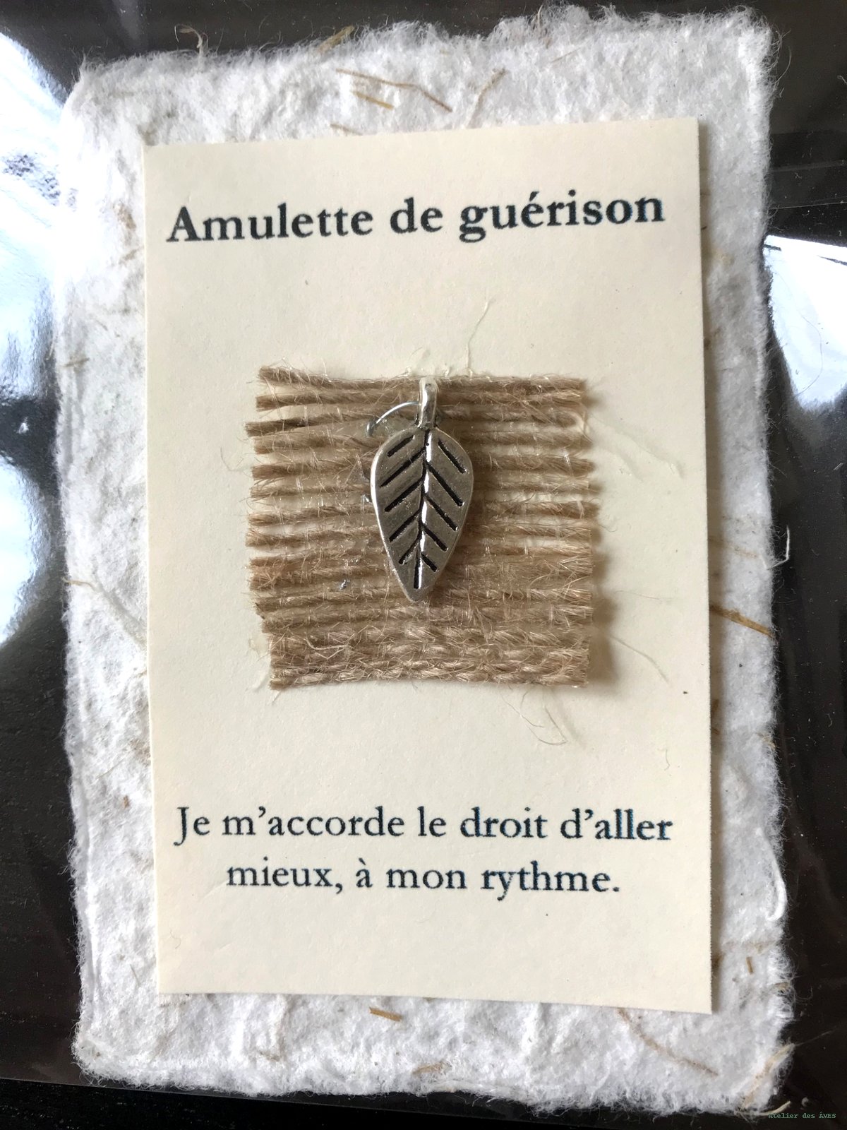 Amulette de guérison — feuille argentée sur toile de jute, carte crème